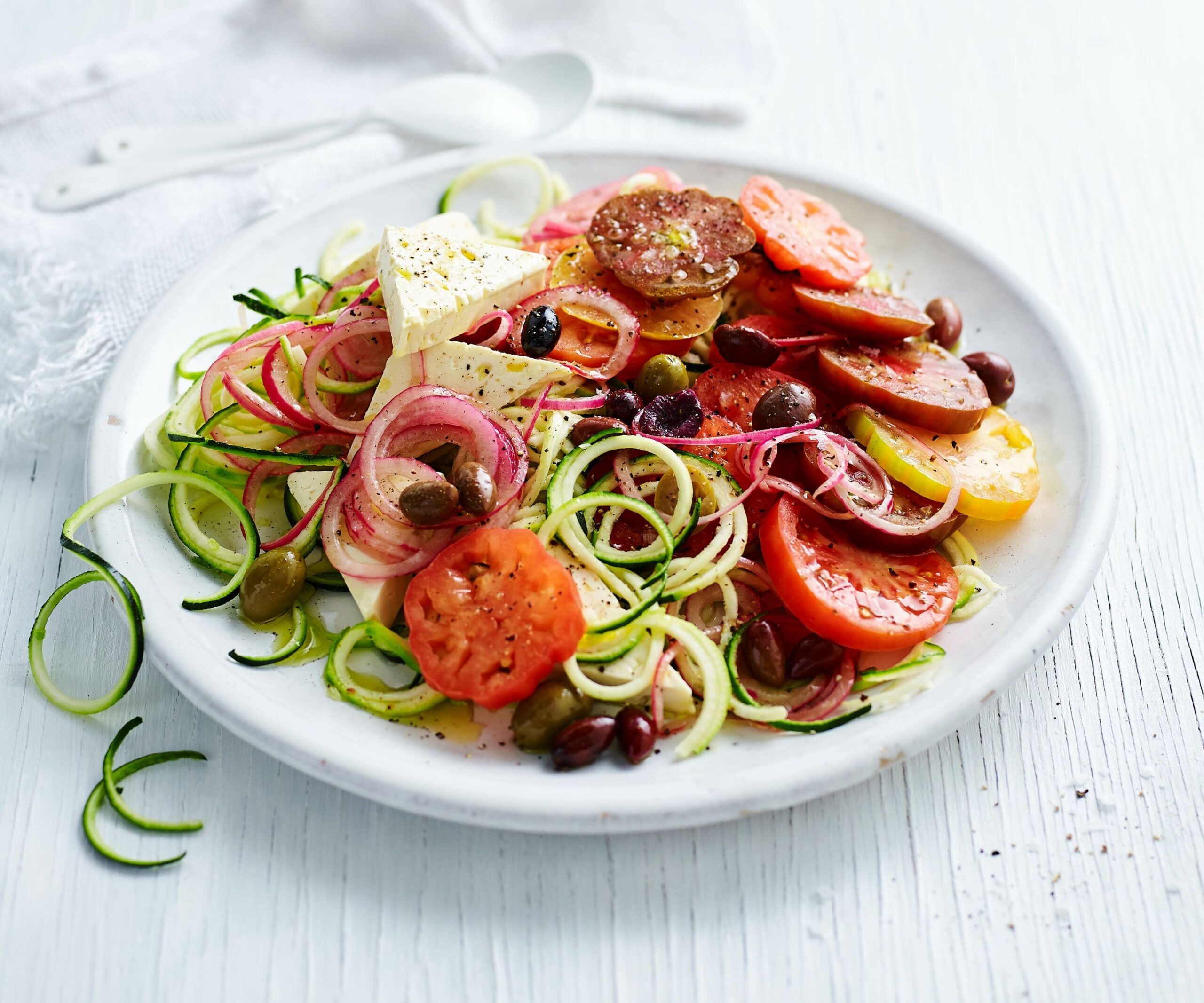 Zucchini spirals topped with tomato and fetta