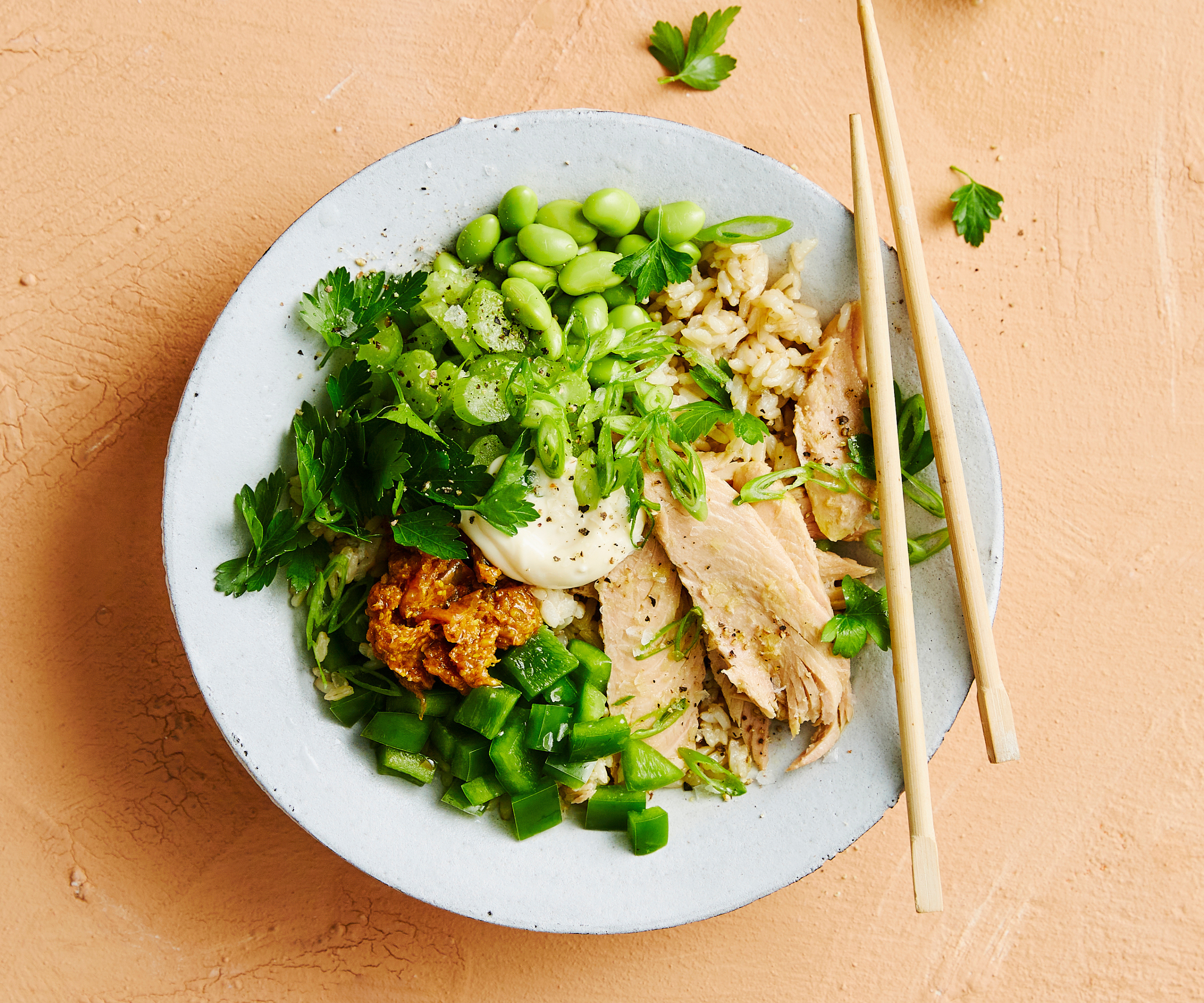 Bowl of tuna and edamame rice bowl with chopsticks.