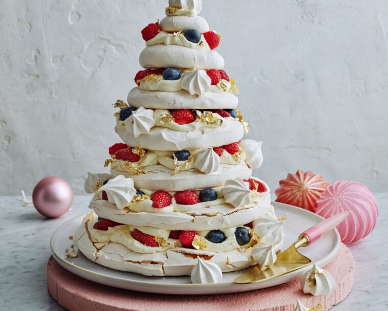 seven-layered pavlova Christmas tree on pink board with white background