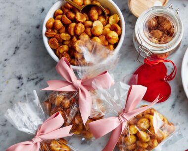 Spiced macadamias in a white bowl plus three gift bags
