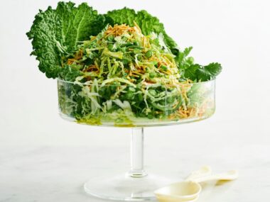 Fresh coleslaw with crispy noodles served in a footed glass bowl.