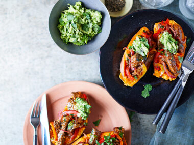 Baked sweet potato halves with steak filling and guacamole.