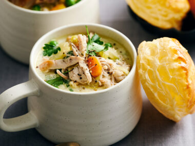 Chicken soup in a mug with pastry round on top
